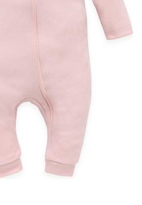 Lichtroze baby rompertje gemaakt van zacht materiaal, met lange mouwen, een rits aan de voorkant en geborduurde enkels. Glad, effen textuur.