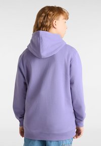 Lila Kapuzenpullover mit langen Ärmeln, weichem Material und Kängurutasche. Die Rückansicht zeigt einen lockeren Schnitt und einen verstellbaren Ausschnitt.