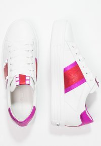 Baskets blanches avec des accents en cuir rose et rouge, bout rond, design épuré et graphiques texturés sur les côtés et à l'arrière.