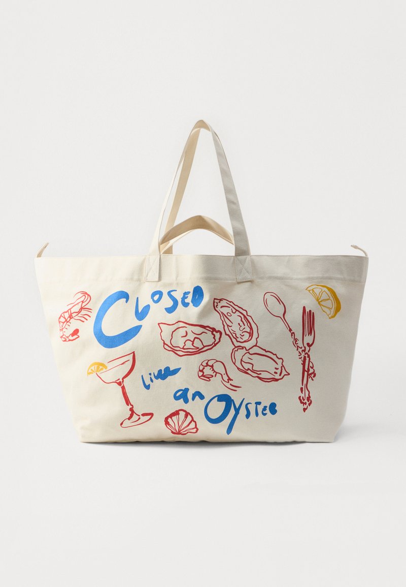 Canvas tote-väska i cream med blå och röda sjömatstema-illustrationer. Har två robusta handtag och en rymlig design.