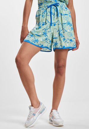 Light green patterned shorts with blue palm tree and cloud designs. Features an elastic waistband with a blue drawstring and trim.