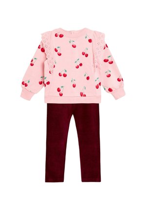 Rosa Sweatshirt mit Kirschmuster und Spitzen Details an den Schultern. Kombiniert mit burgunderfarbenen Cordhosen, beide aus weichem, strukturiertem Stoff.