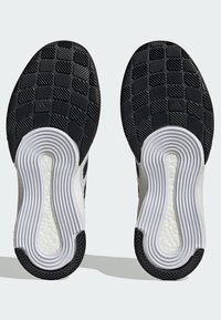 Schwarz-weiße Sport schuhsohlen verfügen über strukturierten Gummi mit einem sechseckigen Muster und markanten weißen Rillen für Grip und Flexibilität.