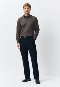 Brown patterned long-sleeve shirt, black trousers, and black dress shoes. Shirt features a button-down front and fitted design.