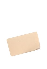 Un solido blocco di sapone beige chiaro con una superficie liscia, bordi leggermente irregolari e alcune linee sottili, appoggiato ad un angolo su uno sfondo bianco.