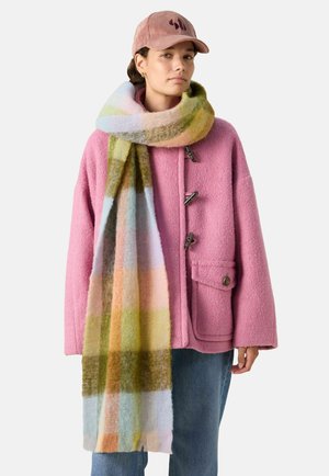 Rosa Wollmantel mit Toggle-Verschlüssen und Seitentaschen, kombiniert mit einem bunten karierten Wollschal in sanften Farben. Cordhut inklusive.