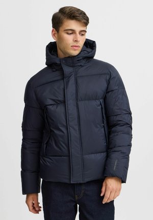 Chaquetón de plumón azul marino con capucha, con textura acolchada, cierre de cremallera y dos bolsillos laterales. Fabricado con material resistente al agua.