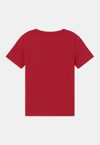 Czerwona koszulka z krótkim rękawem, wykonana z bawełny, z okrągłym dekoltem i gładkim wzorem, bez żadnych grafik ani wzorów.