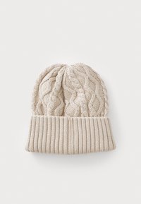 Strikket lue i beige, med et kabelmønster på toppen og en ribbestrikket mansjett nederst, laget av mykt, teksturert stoff.