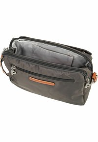 Bolso de nailon gris con una superficie texturizada, que cuenta con una etiqueta de cuero, múltiples compartimentos con cremallera y una correa de hombro desmontable.
