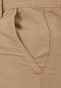 Khaki stof met een gladde textuur heeft een zijvak en zichtbare stiksels, wat de duurzame constructie en het ontwerp laat zien.