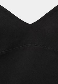 Gros plan sur un tissu noir avec une couture en forme de V et un détail de surpiqûres texturées.