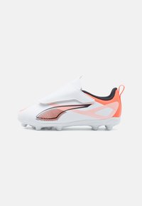Bottines de football blanches avec des accents orange, tige en synthétique, design enveloppant, côtés texturés, lacets plats et une languette à l'arrière pour un enfilage facile.