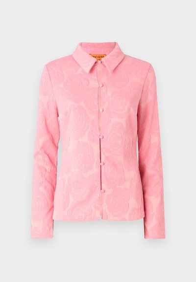 Pink floral-patterned blouse with long sleeves, a classic collar, and front buttons. Made from textured fabric with a soft finish.