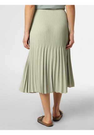 Gonna midi plissettata verde chiaro con una texture liscia, vita elastica e una leggera svasatura all'orlo. Abbinata a sandali piatti marroni.