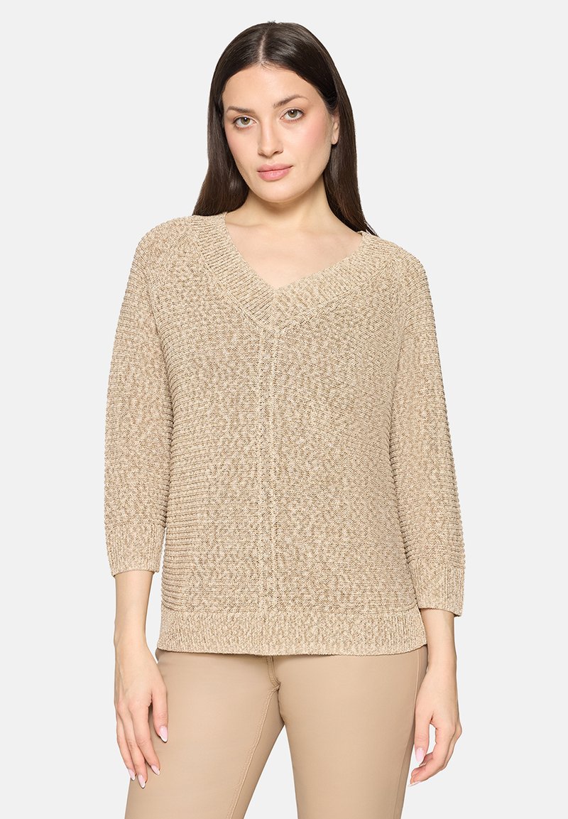 Pull beige en tricot avec col en V, manches trois-quarts et motifs texturés. Tissu doux, léger avec une coupe décontractée.