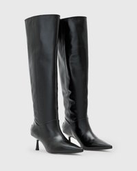 Stivali neri in pelle al ginocchio con punta affilata, tacco sottile e design elegante. Presentano una texture liscia e una silhouette aderente.