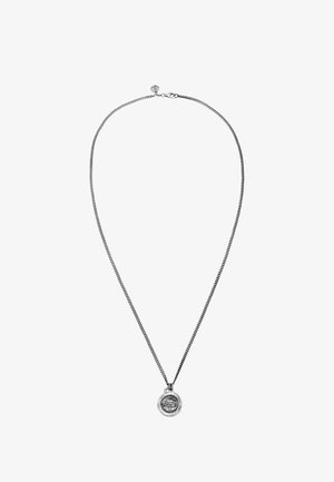 Hõbedane kettkaelakee, millel on ümmargune ripats, millel on tekstureeritud pind ja graveeritud muster. Kett on sile ja paindlik.