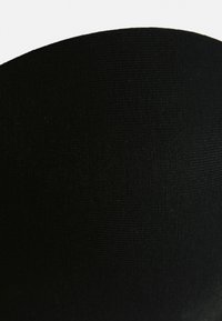 Melnā audumā ir teksturēta virsma, ar gludu, apaļu formu. Materiāls izskatās mīksts un nedaudz stiepjas.