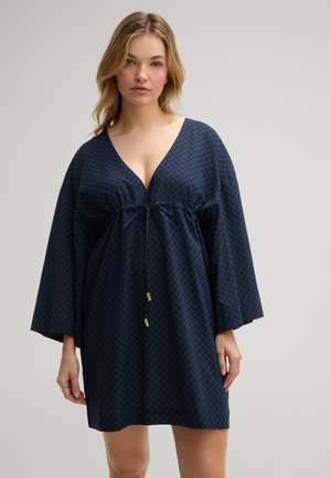 Marineblauwe jurk met een diepe V-hals, strakke taille met een trekkoord met metalen accenten, en wijde mouwen. Glad stoffen textuur.
