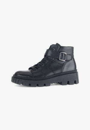 Black leather ankle boots with a chunky sole, lace-up design, and metal buckle accent. Features a textured finish and sturdy construction.