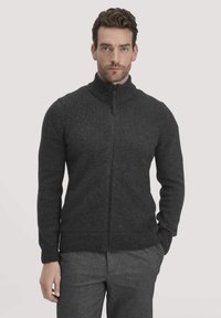 Dunkelgrauer Reißverschluss-Pullover mit hohem Kragen, ausgestattet mit gerippten Bündchen und Saum, gefertigt aus einem strukturierten Strickstoff.