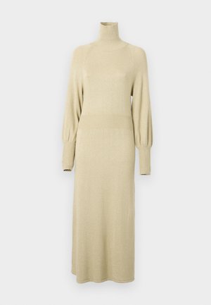 Brede gebreide jurk in zacht beige met een hoge hals, lange pofmouwen en ribbelaccenten bij de taille en de mouwen. Mijdlange uitstraling.