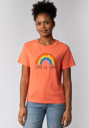 Oranje katoenen t-shirt met een regenboogafbeelding en de tekst "LOVE IS LOVE", ronde halslijn, korte mouwen en een losse pasvorm.