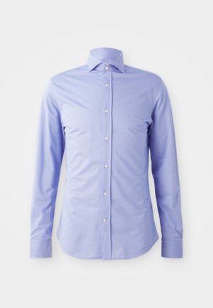 Chemise boutonnée à manches longues de couleur bleu clair en tissu lisse. Présente un col pointu, des boutons blancs et une coupe légèrement ajustée.