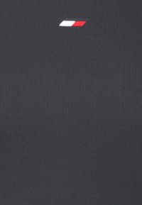 Ciemnoszary prążkowany materiał z małym logo w kolorze czerwonym, białym i niebieskim na środku. Wzór jest prosty i jednorodny w fakturze.