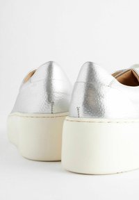 Silver faux leather platform sneakers with a smooth texture and rounded toe. Features a white rubber sole and accent stitching.