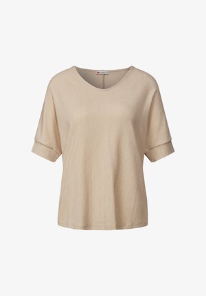 Haut beige à manches courtes avec un décolleté en V, tissu texturé et manches retroussées. Design simple, coupe ample, adapté à un style décontracté.