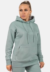 Felpa verde chiaro in morbido tessuto, dotata di tasca frontale, coulisse, polsini a costine e una vestibilità comoda. Logo semplice sul petto.