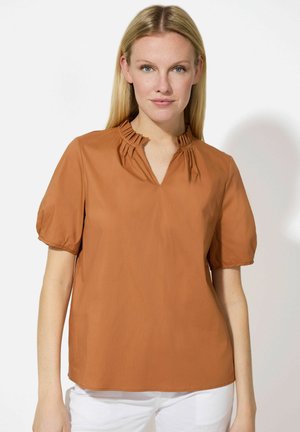 Braunbluse mit kurzen Ärmeln, V-Ausschnitt und gefälteltem Kragen. Hergestellt aus glattem Material, mit lockerer Passform und geradem Saum.