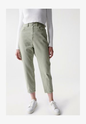 Light green high-waisted jeans with a relaxed fit, featuring five pockets and a button closure, paired with white sneakers on a plain background.