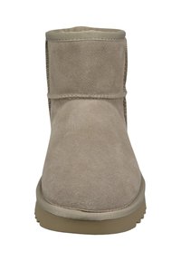 Beige Wildleder-Ankle Boots mit einer abgerundeten Spitze, minimaler Nahtführung und einer strukturierten Sohle. Sie verfügen über eine weiche Innenauskleidung und eine verstärkte Ferse.