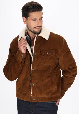 Brown corduroy jacket with a cream faux fur collar, button-up front, and two chest pockets; textured fabric and straight cut design.
