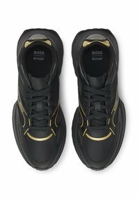 Mustat lenkkarit kultaisilla yksityiskohdilla, joissa on teksturoitu päällinen, nauhakiristys, pehmustettu kaulus ja logo kielessä. Mukavuutta varten Ortholite-pohjallinen.