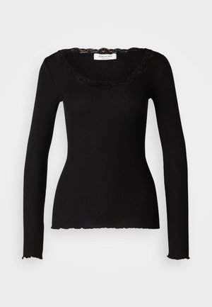 Svart ribbet langermet topp med bølget blondekant i halsen og rå kanter. Slim fit og myk tekstur. Merket synlig ved halsen.