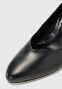 Chaussure habillée pour femme en cuir noir à bout pointu, finition lisse et détail d'ouverture doucement courbé.