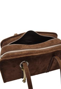 Brązowa torebka z zamszu z górnym zamkiem, wewnętrzną kieszenią i podwójnymi uchwytami. Posiada srebrne akcesoria i gładką teksturę.