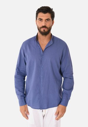 Camicia a maniche lunghe blu navy con bottoni, realizzata in tessuto leggero, con colletto e una texture delicata, abbinata a pantaloni chiari.