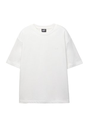 Vit bomull t-shirt med korta ärmar, rund hals och en liten broderad logotyp på vänster bröst. Mjuk textur, avslappnad passform.
