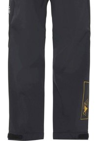 Sorte vandtætte bukser med et strømlinet design, velcro lukninger ved støvlerne og et gult geometrisk logo på låret. Fremstillet af holdbart stof.