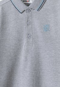 Šviesiai pilkas polo marškinėliai su trimis mygtukais, tamsiai mėlynai ir mėlynai dryžuota apykaklė bei mažas mėlynas siuvinėtas logotipas ant krūtinės.