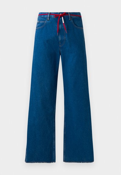 Vaqueros de denim azul de pernera ancha con un cordón rojo en la cintura, que presentan un diseño clásico de cinco bolsillos y dobladillo desflecado.
