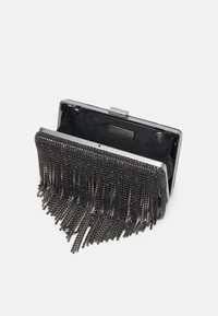 Pochette de soirée à franges en chaîne métallique noire avec cadre argenté, fermoir ouvert et doublure intérieure noire.