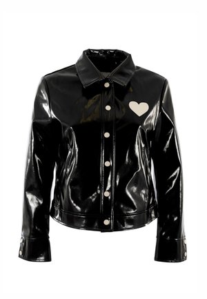 Veste en similicuir noir brillant avec un col classique, un cœur blanc en accent et de gros boutons. Coupe ajustée avec fermeture à l'avant.