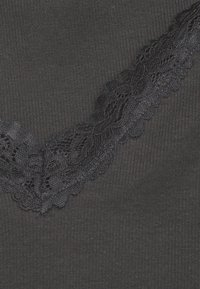 Black ribbed fabric featuring a decorative black lace trim along one edge, with floral patterns and scalloped detailing.