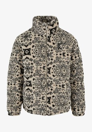 Chaqueta de forro polar con una base crema y un patrón floral y geométrico en negro, cuello alto, cierre de cremallera y bolsillos laterales.